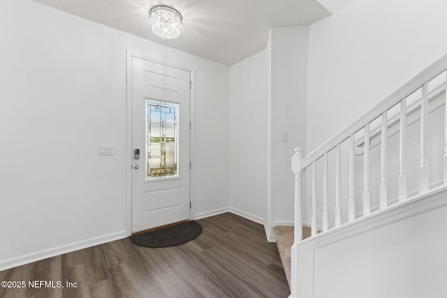 entrance foyer featuring dark hardwood / wood-style flooring and a chandelier