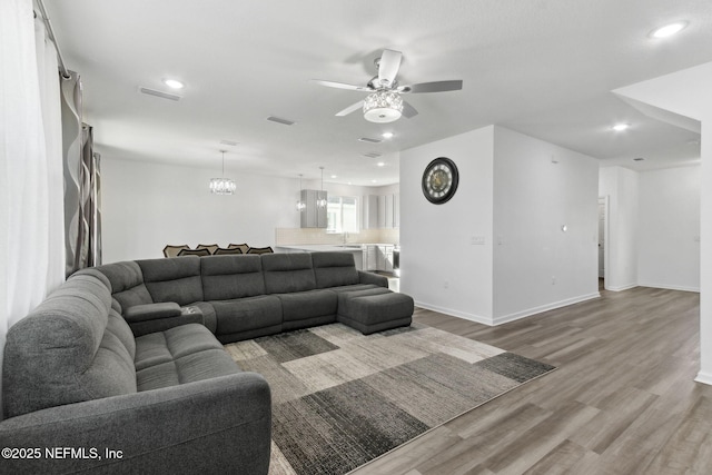 living room featuring ceiling fan and light hardwood / wood-style floors