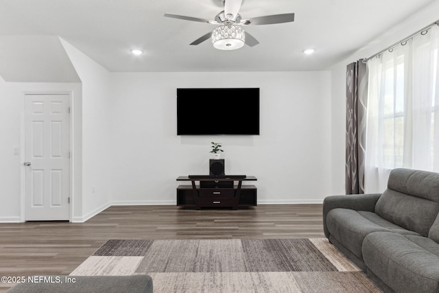 living room featuring ceiling fan and dark hardwood / wood-style floors