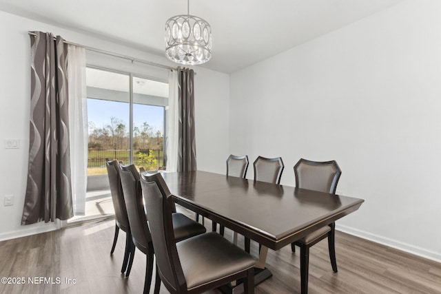 dining area with plenty of natural light, a chandelier, and wood-type flooring