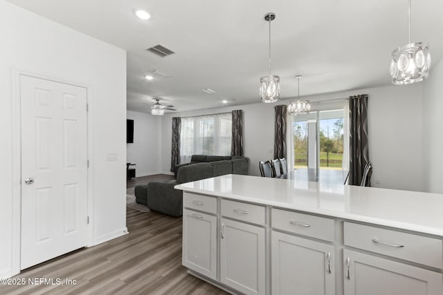 kitchen featuring ceiling fan, hardwood / wood-style floors, and decorative light fixtures