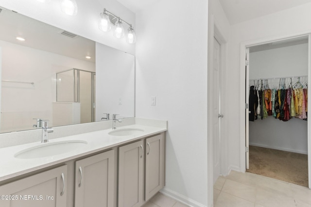 bathroom featuring tile patterned flooring, vanity, and walk in shower