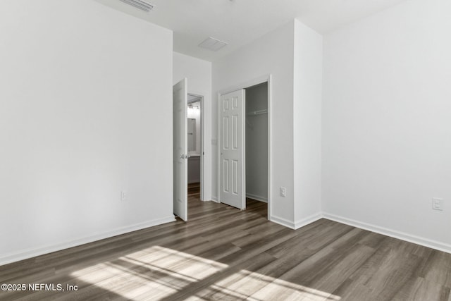 unfurnished bedroom featuring dark hardwood / wood-style flooring and a closet