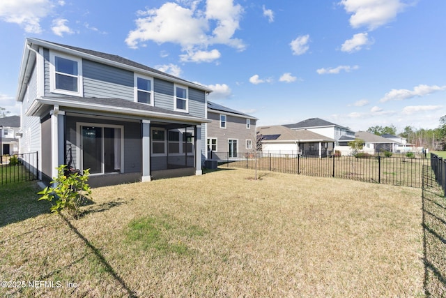 rear view of house with a lawn and a sunroom