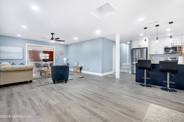 living room with light wood-type flooring and ceiling fan