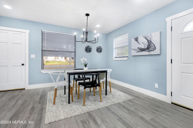 dining space featuring hardwood / wood-style flooring and a notable chandelier