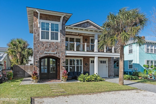 view of front of property with french doors, a balcony, a front lawn, and ceiling fan