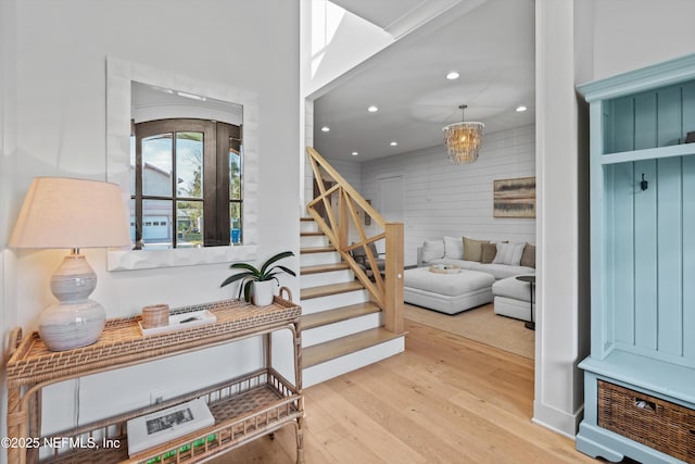 interior space featuring wood walls, light hardwood / wood-style flooring, and a notable chandelier