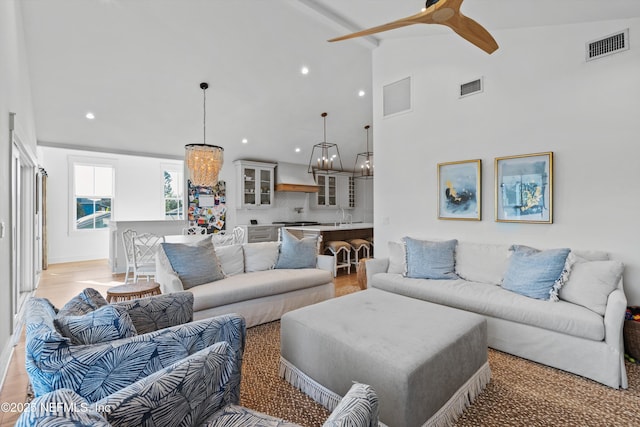 living room with ceiling fan with notable chandelier and lofted ceiling