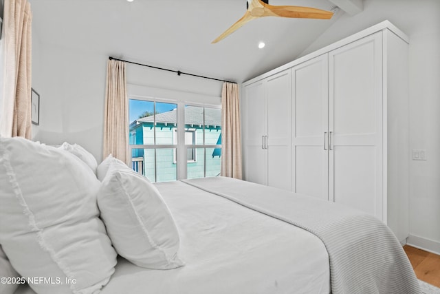 bedroom with lofted ceiling with beams, hardwood / wood-style flooring, and ceiling fan