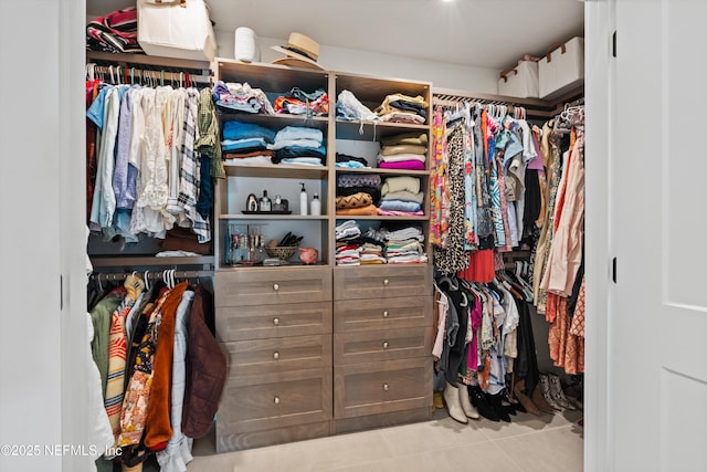 walk in closet with light tile patterned floors