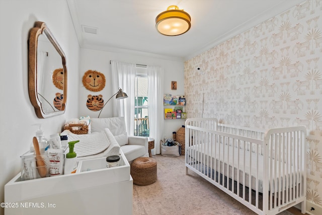 bedroom with carpet flooring, a nursery area, and ornamental molding