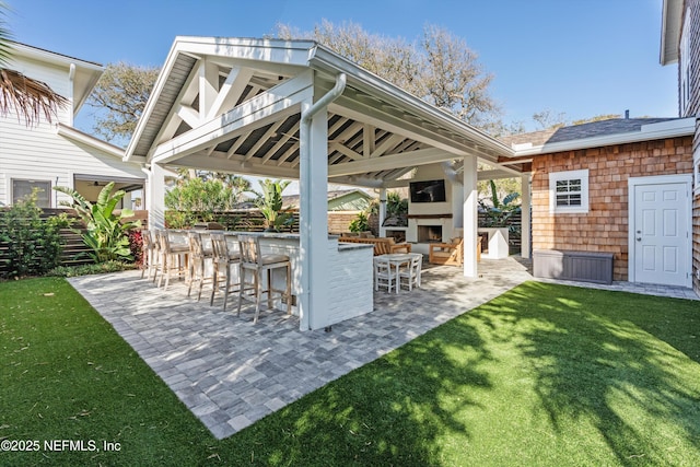 view of patio / terrace with exterior bar, a gazebo, and an outdoor fireplace