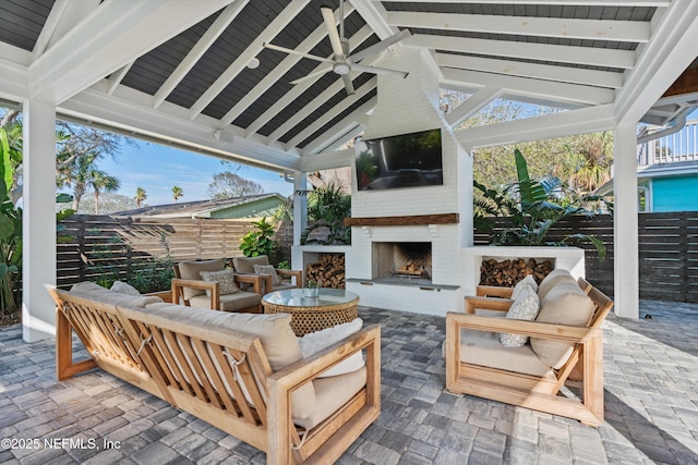 view of patio / terrace featuring an outdoor living space with a fireplace, ceiling fan, and a gazebo