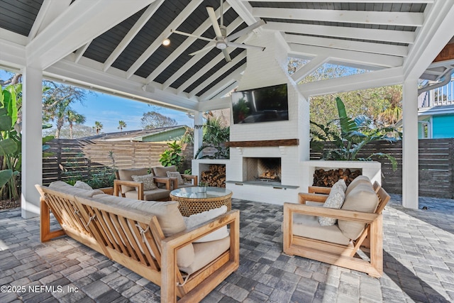 view of patio featuring an outdoor living space with a fireplace and ceiling fan