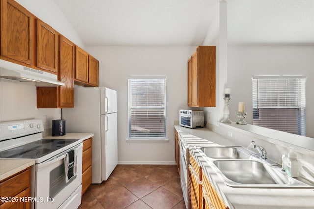 kitchen with electric range, sink, dishwashing machine, and dark tile patterned flooring