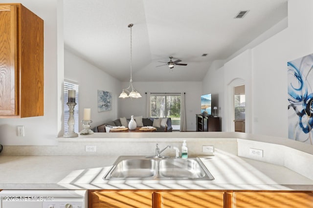 kitchen featuring ceiling fan with notable chandelier, lofted ceiling, sink, and decorative light fixtures