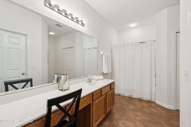 bathroom with a shower with curtain, vanity, and a textured ceiling