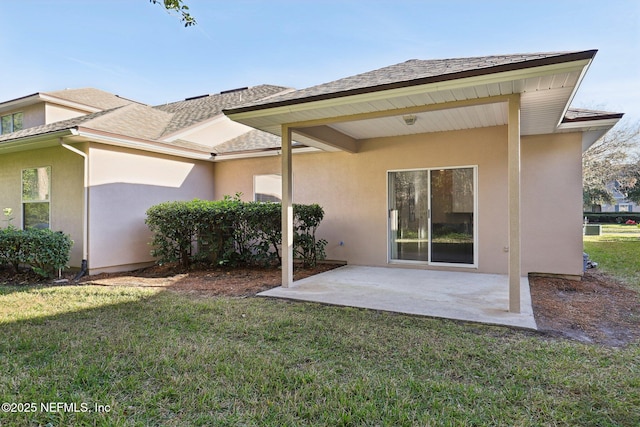 back of property with a lawn and a patio