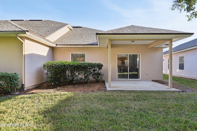 rear view of house with a lawn and a patio