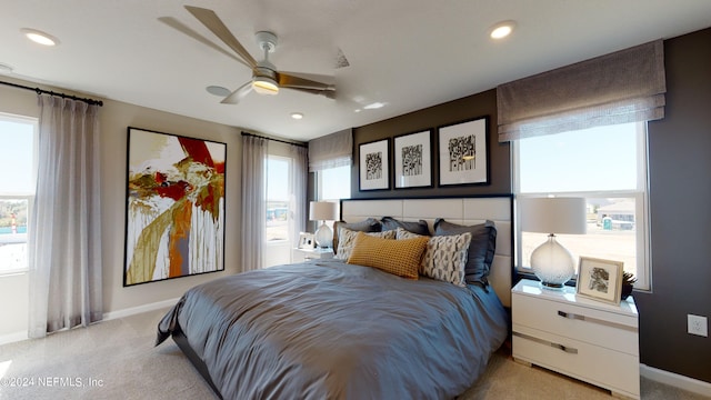 carpeted bedroom featuring multiple windows and ceiling fan