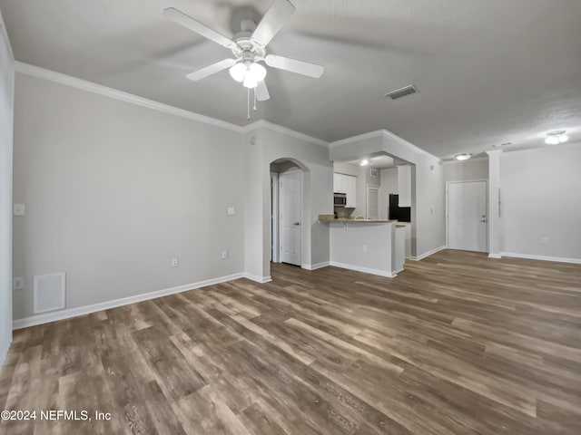 unfurnished living room featuring dark wood-type flooring, ceiling fan, and crown molding