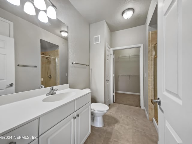 bathroom featuring vanity, toilet, and a shower with shower door