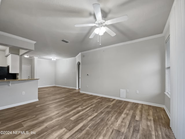 unfurnished living room featuring ceiling fan, wood-type flooring, and crown molding