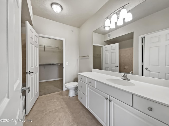 bathroom featuring tile patterned flooring, vanity, and toilet