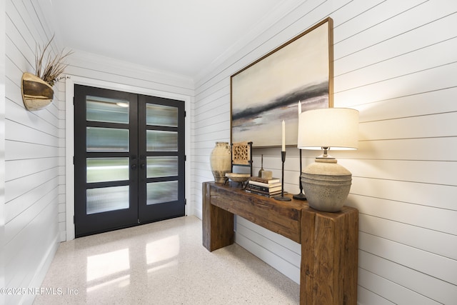 doorway featuring ornamental molding, wooden walls, and french doors