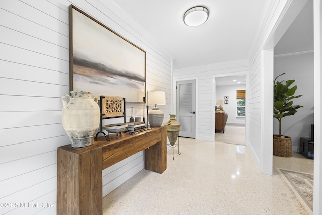 hall featuring wood walls and ornamental molding