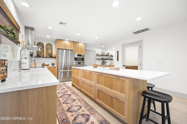 kitchen featuring a center island, a kitchen breakfast bar, light tile patterned floors, light stone countertops, and appliances with stainless steel finishes