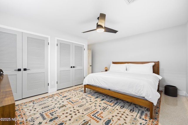 bedroom featuring ceiling fan and two closets