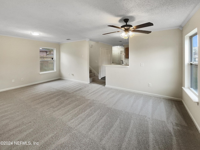 carpeted empty room featuring ceiling fan, a textured ceiling, and ornamental molding