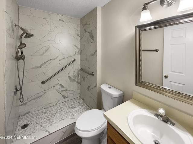 bathroom with tiled shower, a textured ceiling, vanity, and toilet