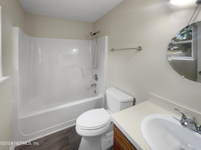 full bathroom with hardwood / wood-style flooring, vanity, shower / bathtub combination, and toilet