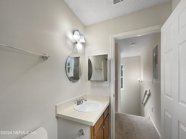 bathroom with vanity, a textured ceiling, and toilet