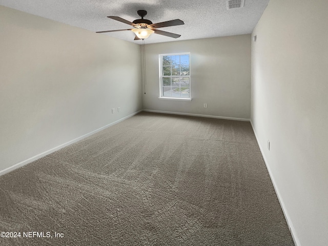 empty room with carpet, ceiling fan, and a textured ceiling