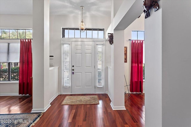 foyer entrance with dark hardwood / wood-style flooring and a towering ceiling