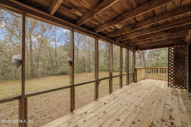 unfurnished sunroom with a healthy amount of sunlight, wooden ceiling, and beam ceiling