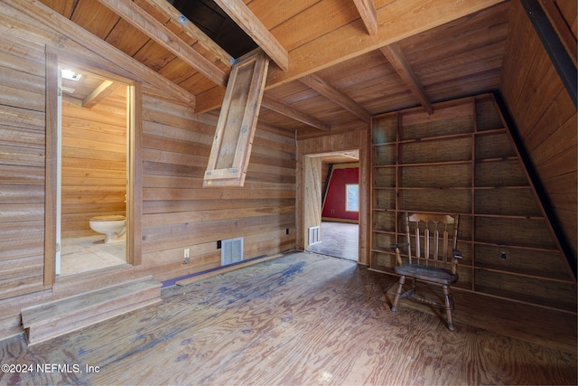 unfurnished living room with vaulted ceiling with beams, wood ceiling, and wooden walls