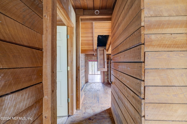 corridor featuring wood ceiling and wooden walls