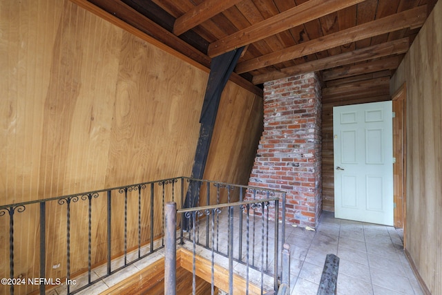 hall featuring beamed ceiling, wooden ceiling, and wooden walls