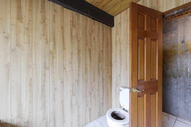 bathroom featuring wood walls, tile patterned flooring, wooden ceiling, and toilet