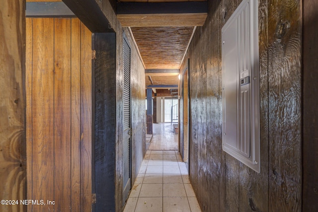 hallway featuring light tile patterned floors and wood walls