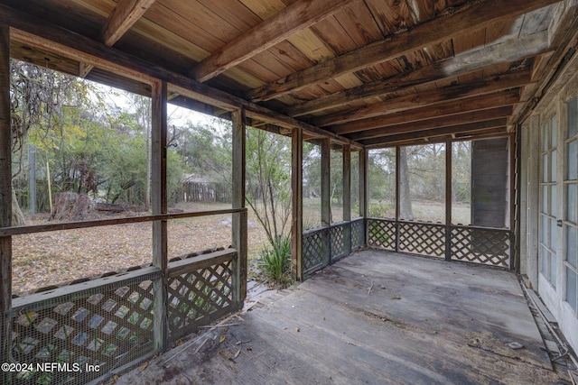 unfurnished sunroom with beam ceiling