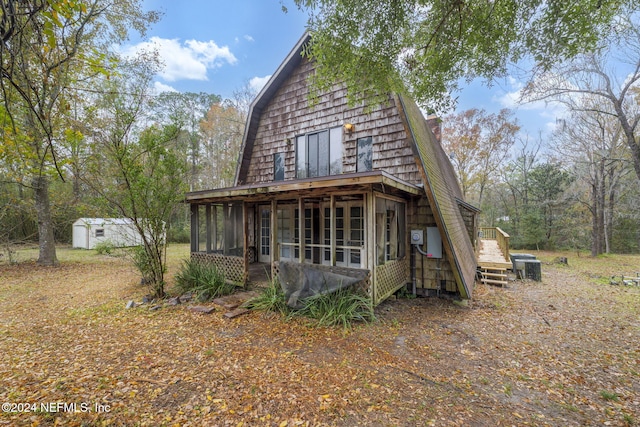 exterior space featuring a shed and a sunroom