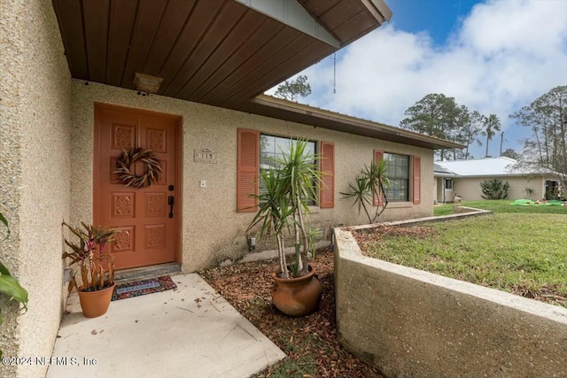 doorway to property with a yard