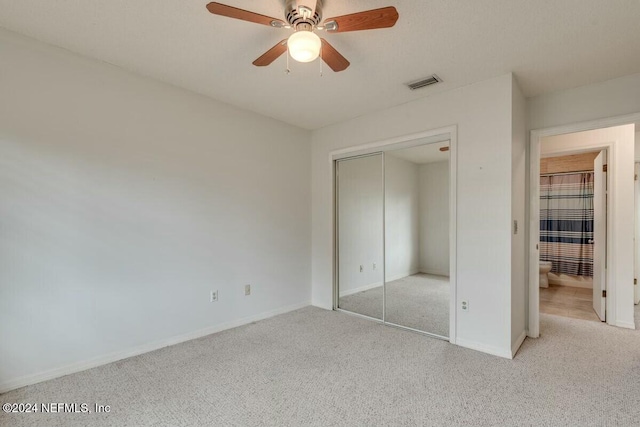 unfurnished bedroom featuring ceiling fan, a closet, and light carpet