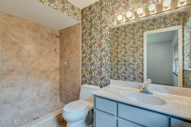 bathroom featuring vanity, toilet, and tiled shower